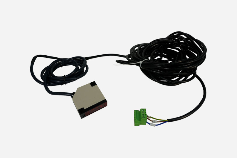 Ein langes durchgehendes schwarzes Kabel mit mit Lichtschranke und Anschluss